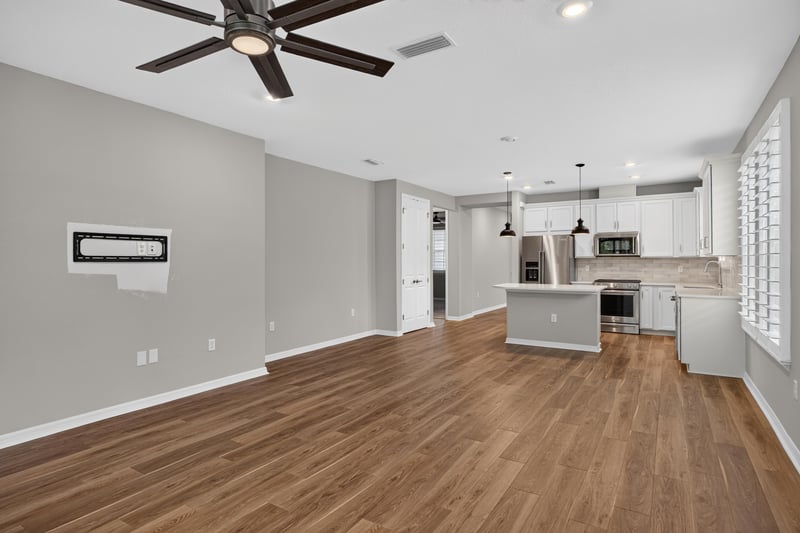 Open kitchen and living area with island and pendant lights at 171 Oyster Shell Ter, Nocatee, FL 32081
