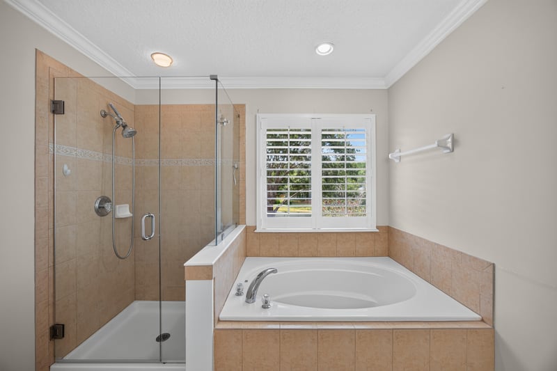 Primary bathroom with glass shower and soaking tub at 1493 Greyfield Dr, St. Augustine, FL 32092