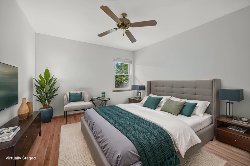 Bedroom staged with gray upholstered headboard and accent chair at 2460 San Sago Ln, Jacksonville, FL
