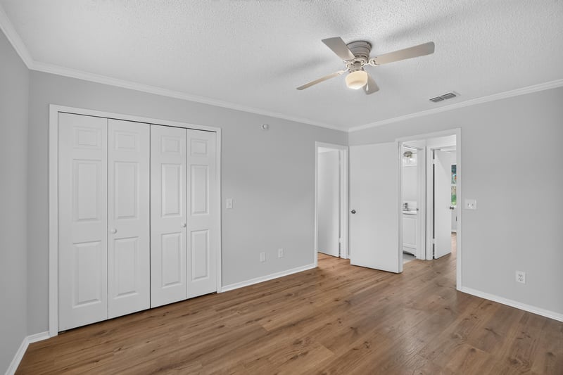 Hallway with double closets and wood floors at 8047 Mactavish Way E, Jacksonville, FL 32244