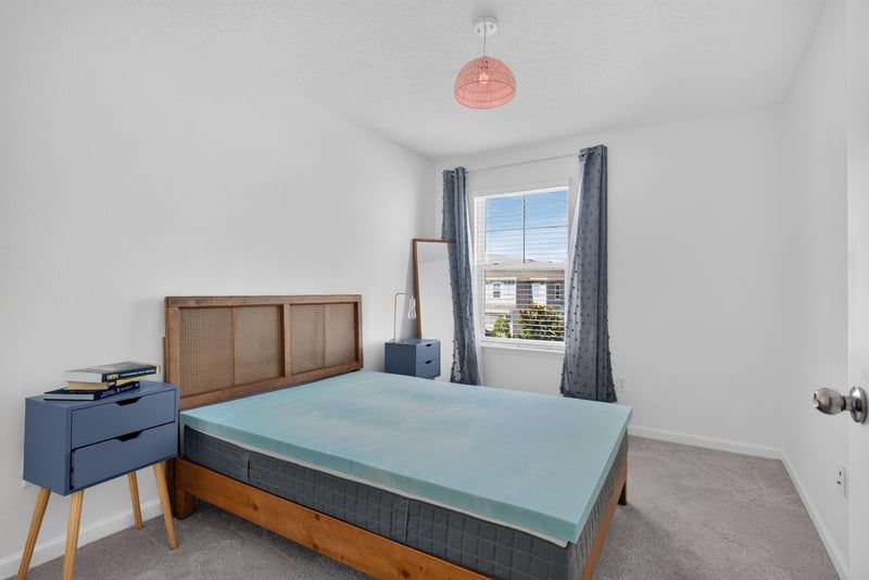 Secondary bedroom with bed and nightstand at 1186 Beach Dune Dr, Jacksonville, FL 32233