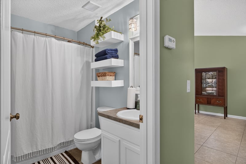 Bathroom with open shelving over toilet at 1589 Backwater Drive, Middleburg, FL 32068