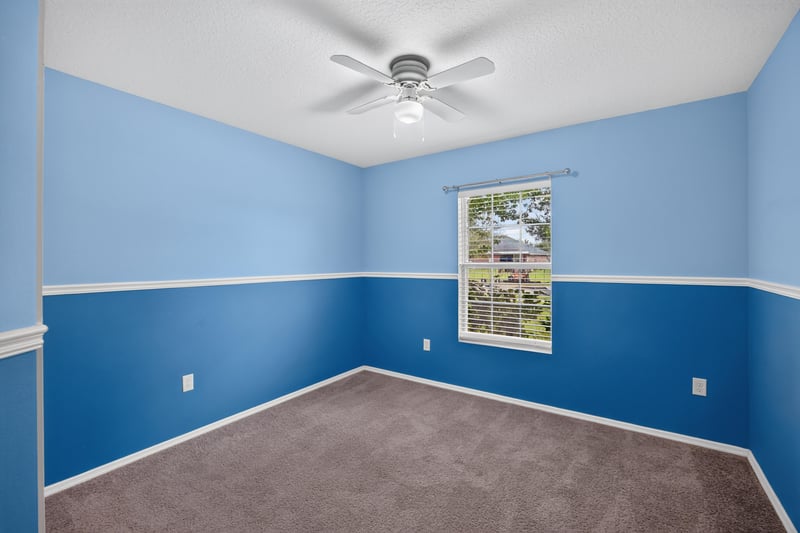 Empty bedroom with blue accent walls and carpet at 7545 Lirope St, Jacksonville, FL 32244