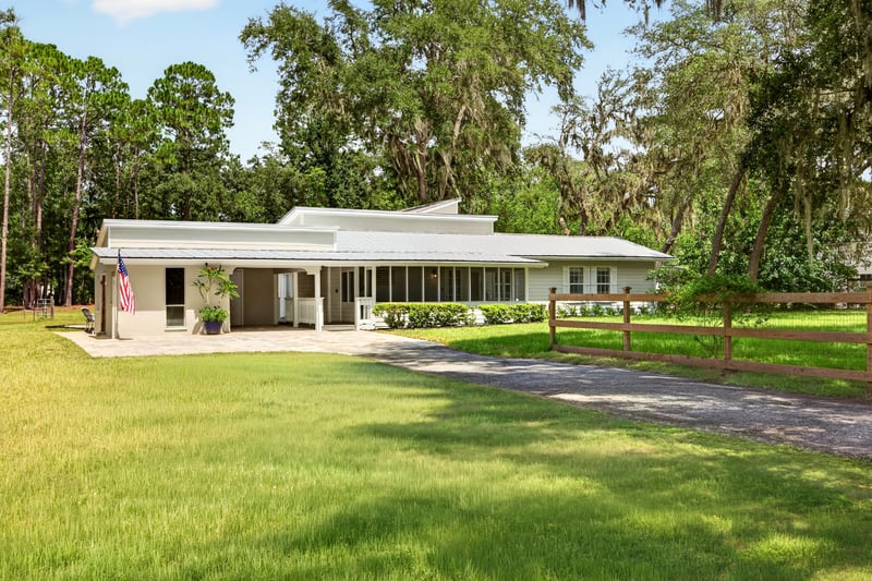 Front exterior with screened porch and long driveway at 1161 Whispering Pines Rd, Jacksonville, FL 32259