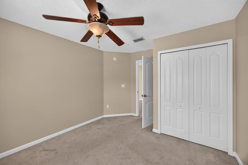 Bedroom with closet doors and ceiling fan at 1572 Biscayne Bay Dr, Jacksonville, FL 32218
