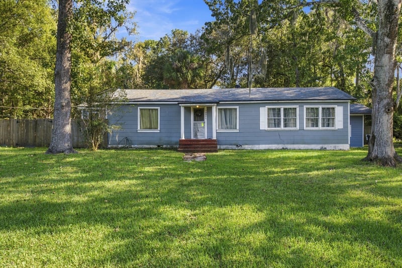 Front exterior with wide lawn and mature trees at 1807 Idlewild Ave, Green Cove Springs, FL