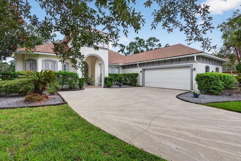 Front exterior with palm landscaping and three-car garage at 4109 Eagle Landing Pkwy, Orange Park, FL 32065