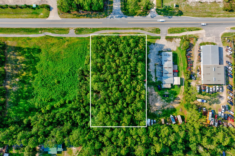 Aerial of the outlined parcel beside storage buildings and trucks at 4393 Co Rd 218, Middleburg, FL 32068