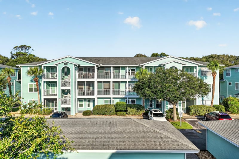 Front exterior of the teal condo building from the parking area at 206 16th St, St. Augustine, FL 32080