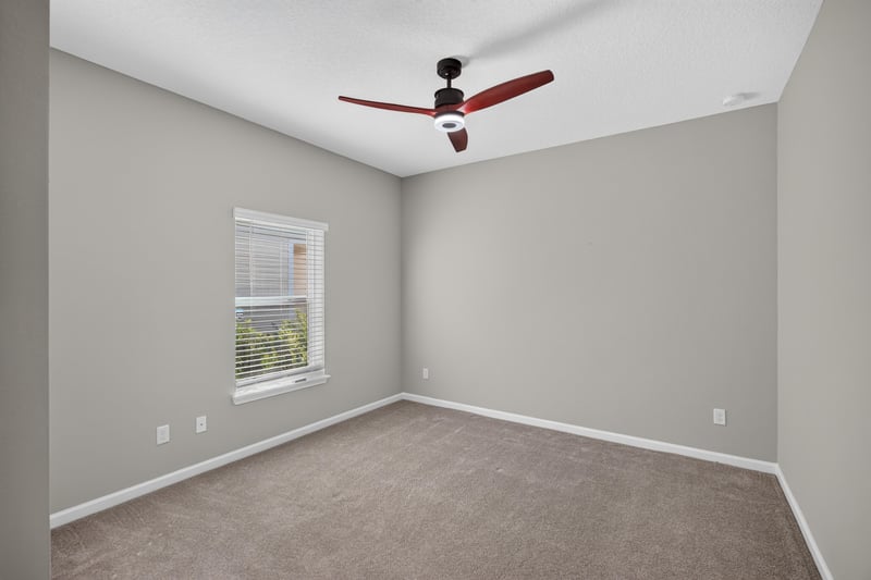 Carpeted bedroom with window and ceiling fan at 75875 Saffron Ln, Yulee, FL 32097