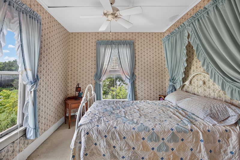 Bedroom with floral bedspread and curtains at 1173 US-17, Satsuma, FL 32189