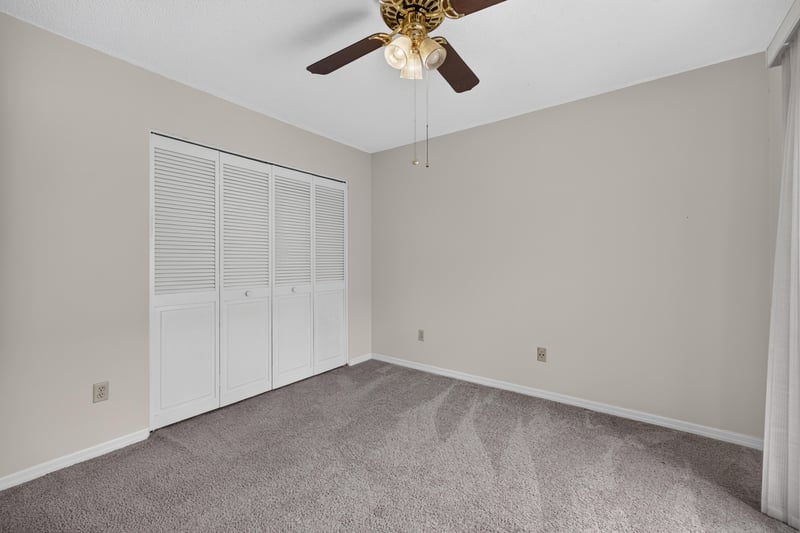 Carpeted bedroom with closet doors at 3407 Fairbanks Grant Rd N, Jacksonville, FL 32223