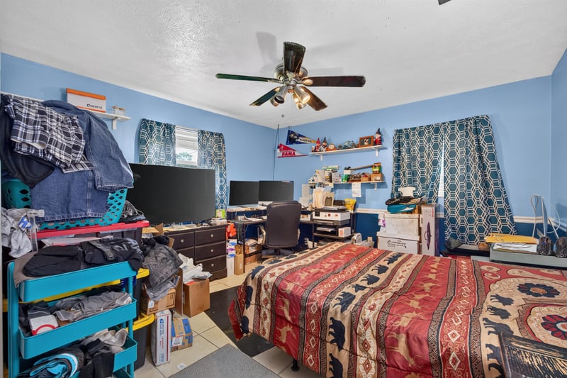 Bedroom with blue walls and wall-mounted TV at 6059 Karen St, Jacksonville, FL 32244