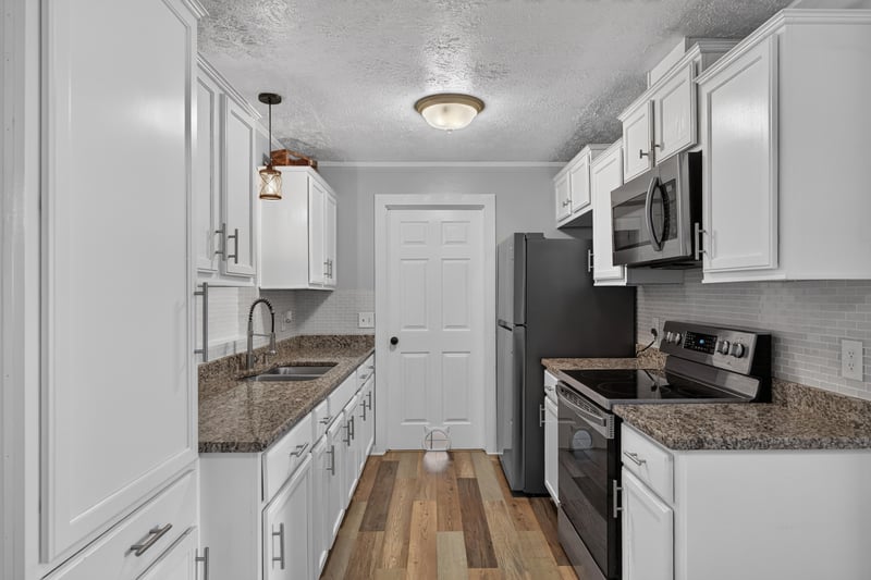 Kitchen with white cabinets and stainless refrigerator at 6757 Deer Springs Rd, Keystone Heights, FL 32656