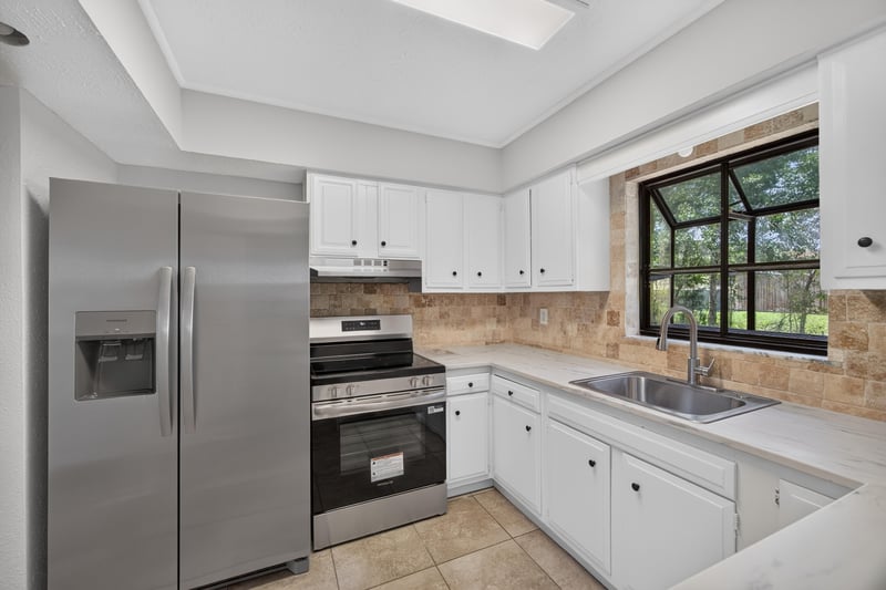 Kitchen with stainless appliances, tile backsplash and window over sink at 7453 Jade Dr N, Jacksonville, FL 32210