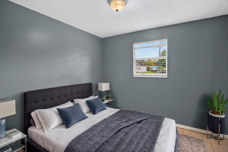 Bedroom virtually staged with dark upholstered bed at 6745 Jack Horner Ln, Jacksonville, FL 32210
