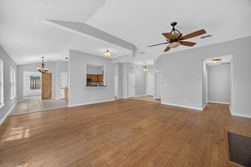 Open living room with ceiling fan and sliding glass door at 456 Bay Point Way N, Jacksonville, FL 32259