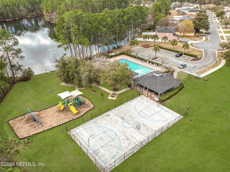 Aerial view of community pool, playground, and pond in Adams Lake, Jacksonville, FL