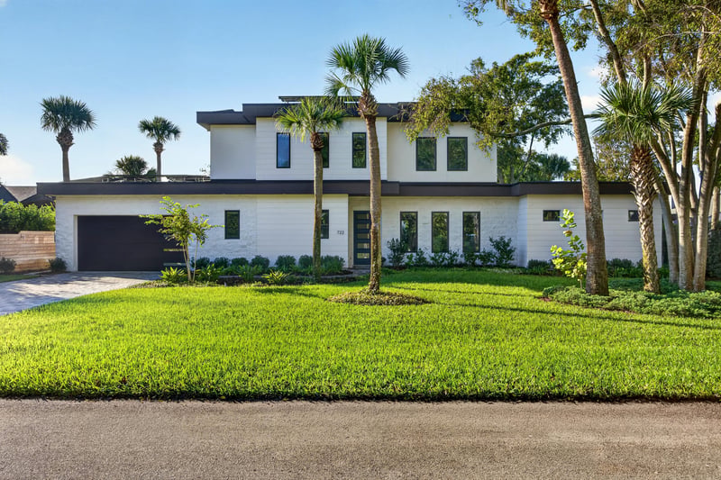 Front exterior with manicured lawn and palm trees at 722 3rd Ave N, Jacksonville Beach, FL