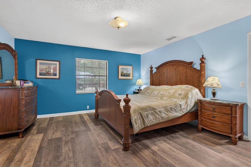 Primary bedroom with wood bed frame and nightstands at 3249 Maryland Ave, Green Cove Springs, FL