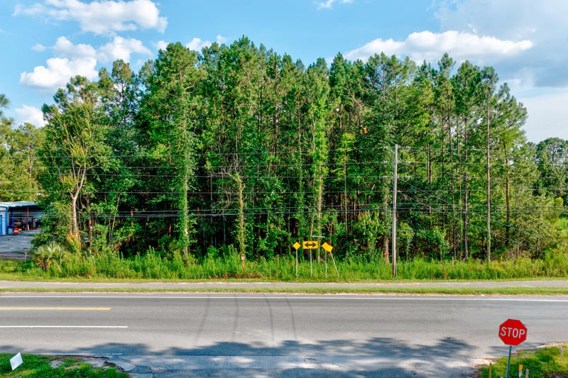 Low drone view along Co Rd 218 with roadside trees and a school bus at 4393 Co Rd 218, Middleburg, FL 32068