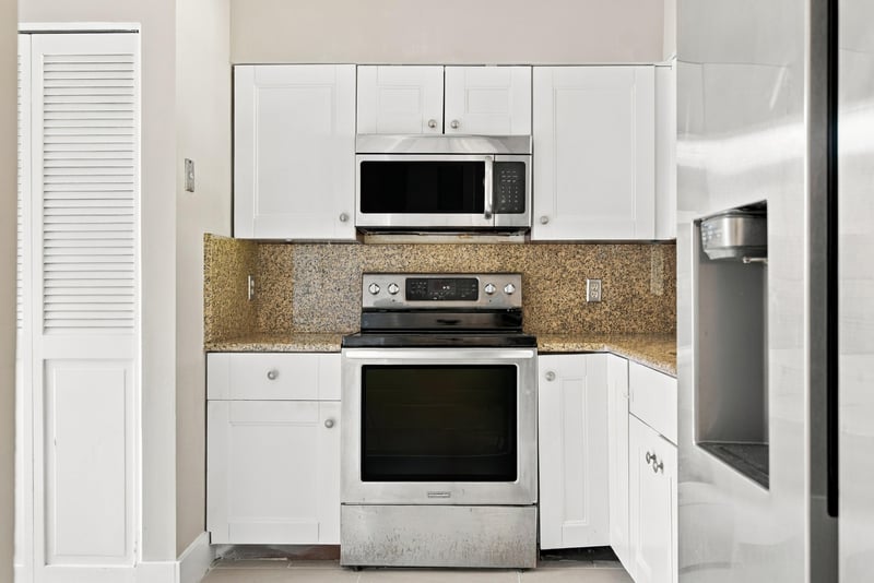 Kitchen with white cabinets and granite counters at 7703 Las Palmas Way