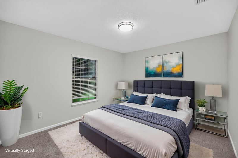 Virtually staged bedroom with bed and wall art at 706 Bonaparte Dr, Jacksonville, FL 32218