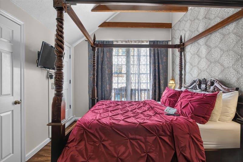 Bedroom with a four-poster bed and red bedding at 115 Cordova St, St. Augustine, FL