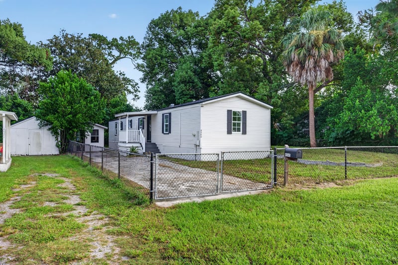Front exterior at day-to-dusk with long driveway and fenced yard at 4565 Appleton Ave, Jacksonville, FL