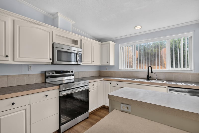 Kitchen with white cabinets and window over sink at 3215 Robin Ln, Middleburg, FL