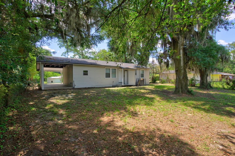 Backyard with open lawn and mature trees at 855 Cornwallis Dr, Jacksonville, FL