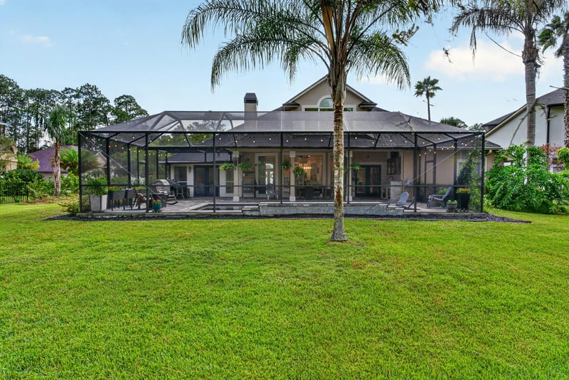 Back exterior with screened lanai and lawn at 2304 Spring Hill Ct, Orange Park, FL