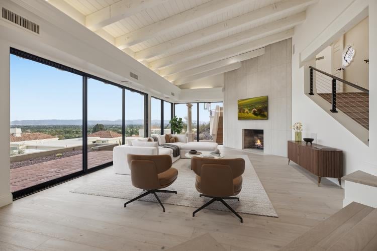 Living room with a wall of glass and the city view, virtually staged