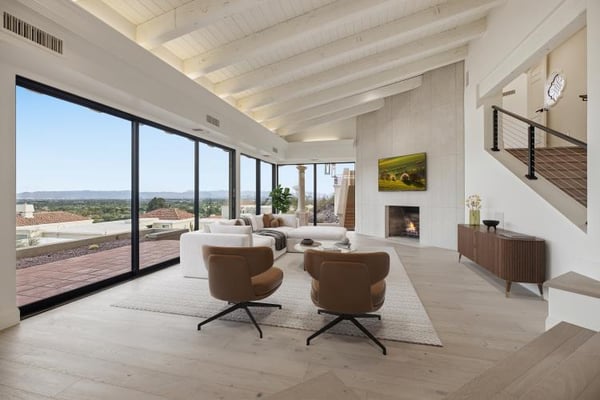 Living room with a wall of glass and the city view, virtually staged