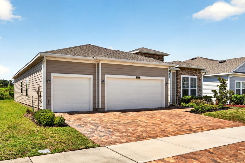 Front exterior view of garage and landscaped yard at 9942 Lovage Ln, Jacksonville, FL 32219
