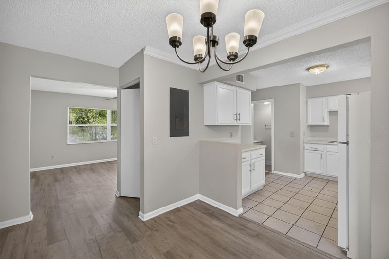 Kitchen and dining area with white cabinets and chandelier at 2658 Trollie Ln apt 1, Jacksonville, FL 32211