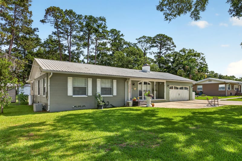 Front view of home with orange front door and attached garage at 5843 Ovella Rd, Jacksonville, FL 32244