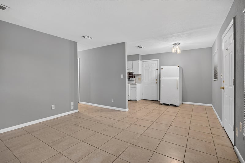 Empty room with doorways to kitchen and hall at 4030 Leonard Cir W, Jacksonville, FL 32209
