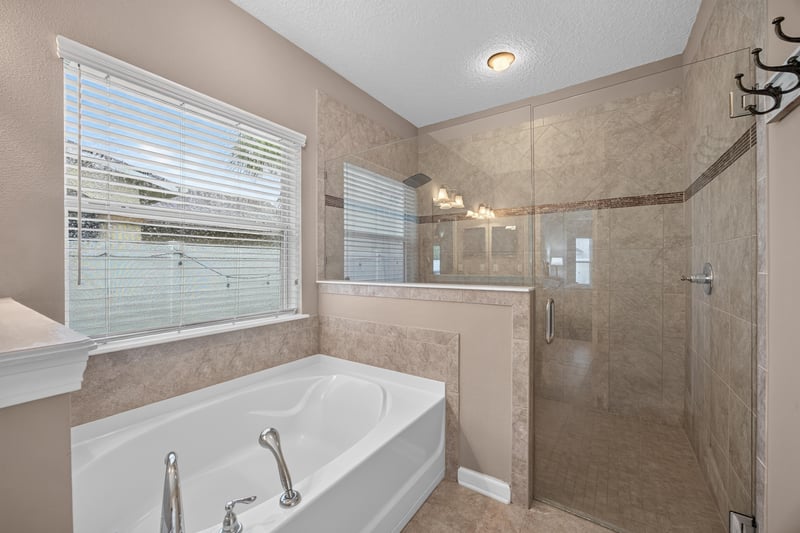 Primary bathroom glass shower and soaking tub at 538 Porta Rosa Circle, St. Augustine, FL 32092