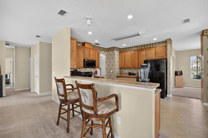 Kitchen with wood cabinets and bar seating at 2875 Pebblewood Ln, Orange Park, FL 32065