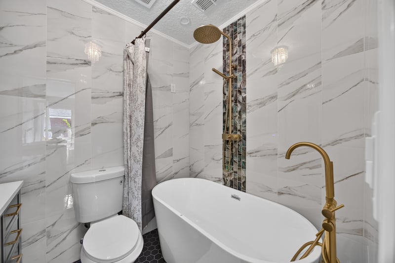 Bathroom with freestanding tub and marble walls at 2125 Blue Heron Cove Dr, Orange Park, FL 32003