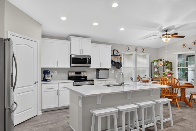 Kitchen with white cabinets and dining table at 4319 Green River Pl, Middleburg, FL 32068