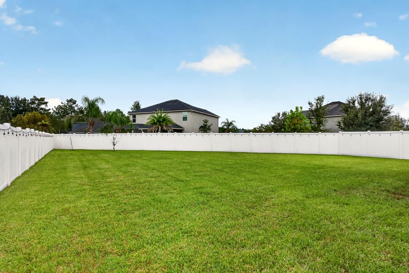 Backyard lawn with white vinyl fence at 538 Porta Rosa Circle, St. Augustine, FL 32092