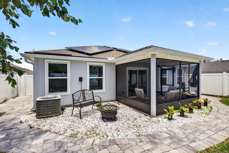 Backyard view of the screened porch and paver patio at 10066 Andean Fox Dr, Jacksonville, FL 32222