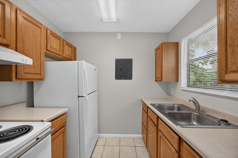Kitchen with wood cabinets, white range, and tile floor at 2717 Trollie Ln, Jacksonville, FL
