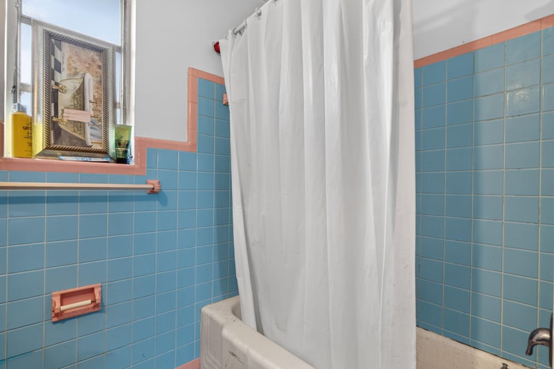 Bathroom with tiled tub and shower curtain at 450 E 46th St, Jacksonville, FL 32208
