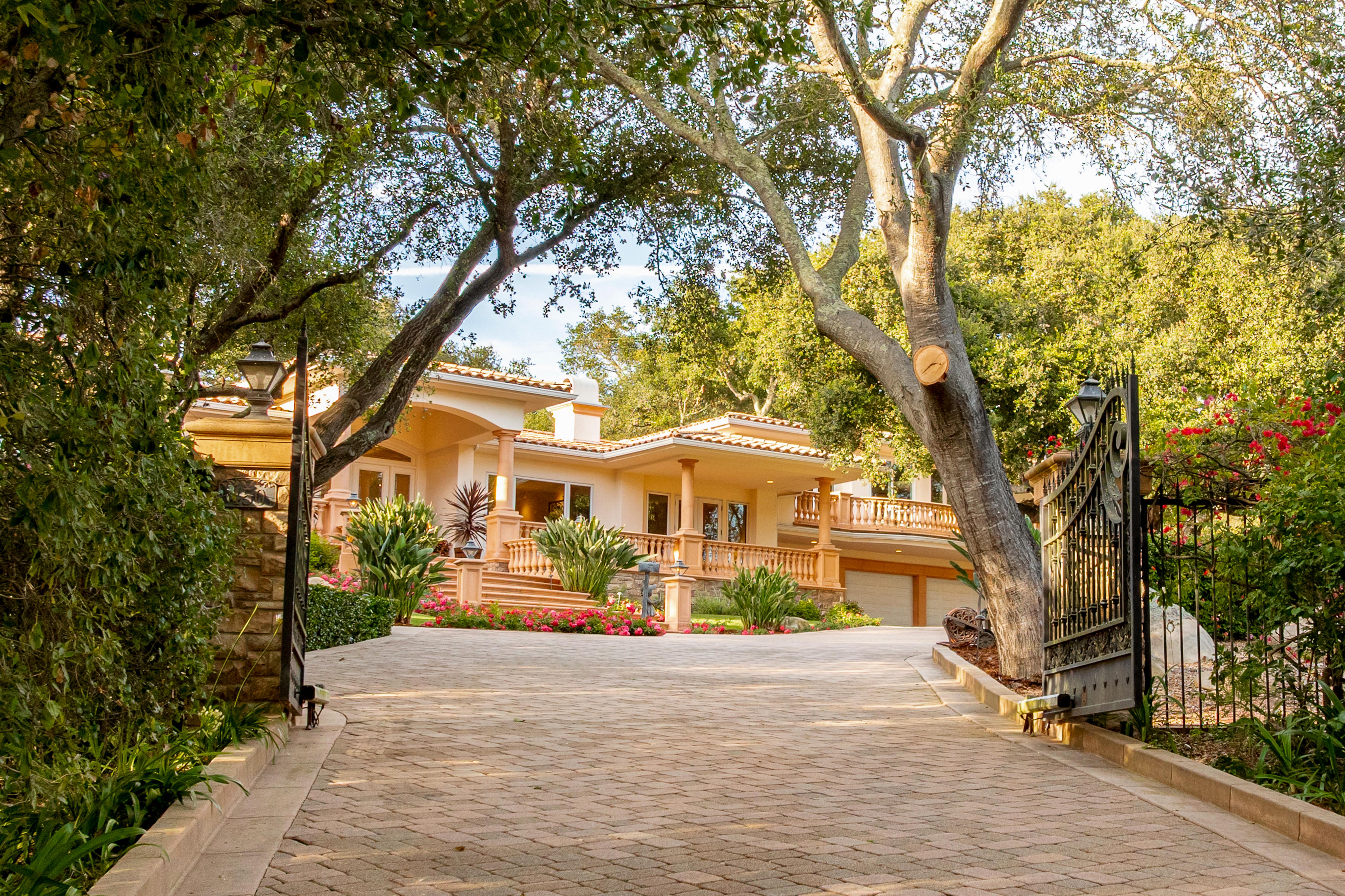 Aerial drone photography of hilltop estate at 450 El Cielito Rd, Santa Barbara — real estate drone photography revealing roofline, mature landscaping, and sweeping Pacific Ocean and Channel Islands panorama above the American Riviera. Our team captured still photography, aerial drone photography, twilight photography, a Matterport virtual tour, a 2D floor plan, and a custom property website from afternoon through twilight.