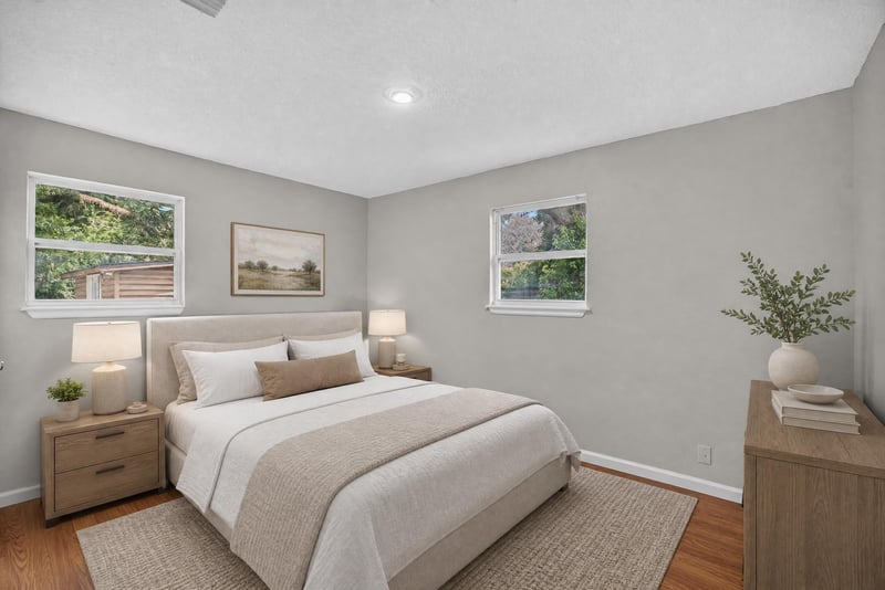 Virtually staged bedroom with bed and nightstand at 7015 Miss Muffet Ln N, Jacksonville, FL 32210