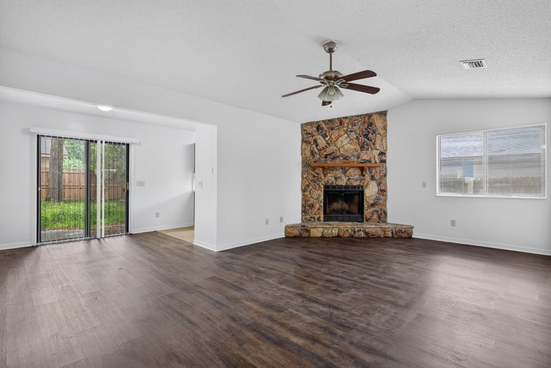 Living room with stone fireplace and wood floor at 1445 Classic Oak Rd W, Jacksonville, FL