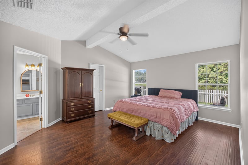 Primary bedroom with wood floor and armoire at 11828 Heather Grove Ln, Jacksonville, FL